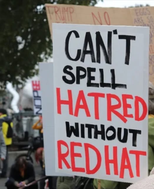 Sign from nokings protest that says "Can't spell HATRED without REDHAT"
