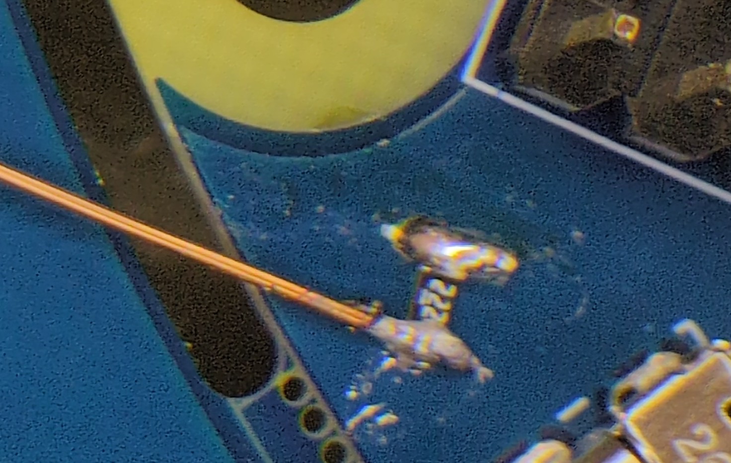 A closeup of a PCB with a bodge SMD resistor and a bodge wire running from it