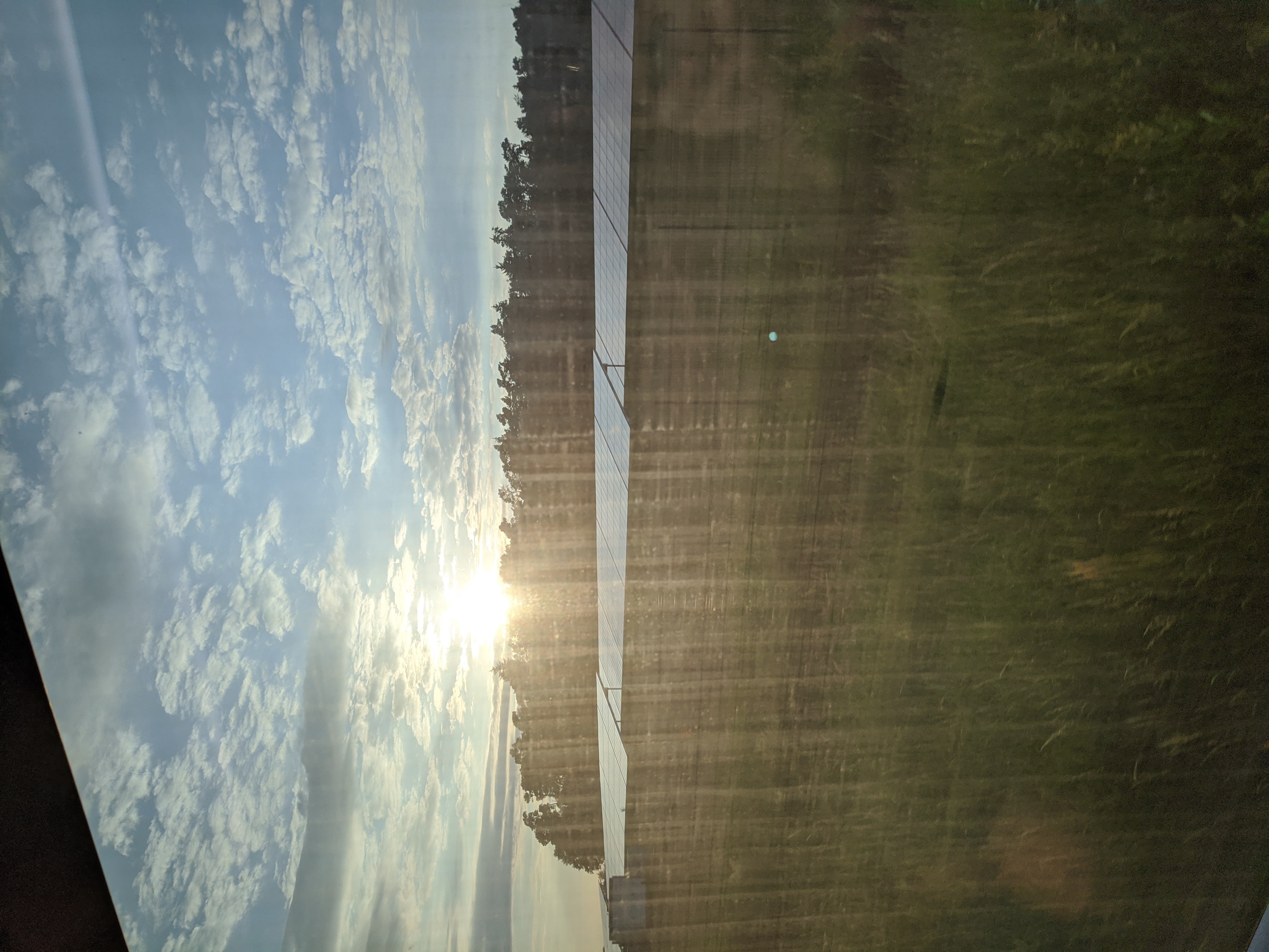 The setting sun over a field photographed from a train window