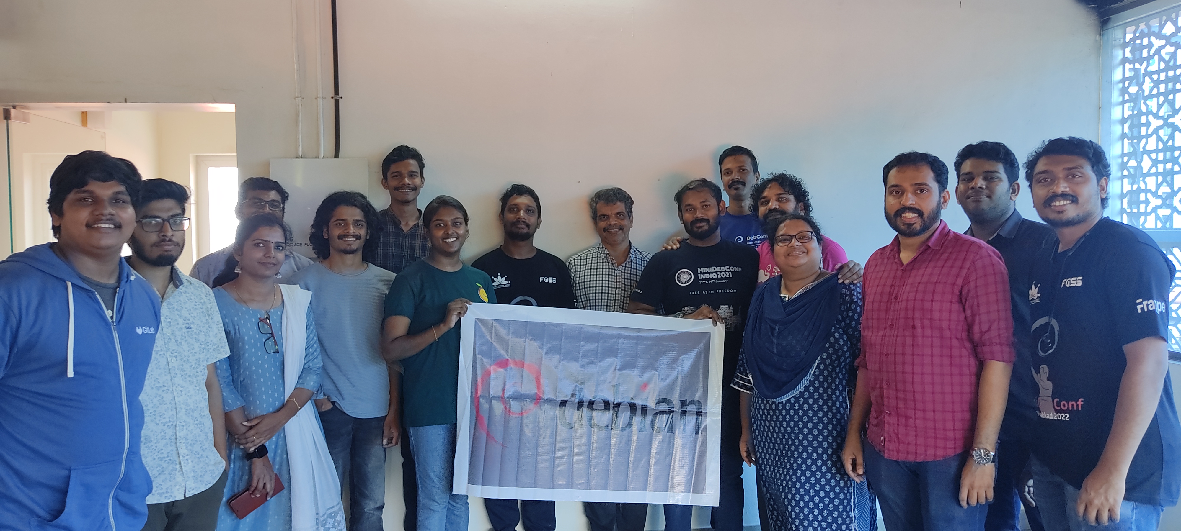 Group photo of attendees with Debian banner