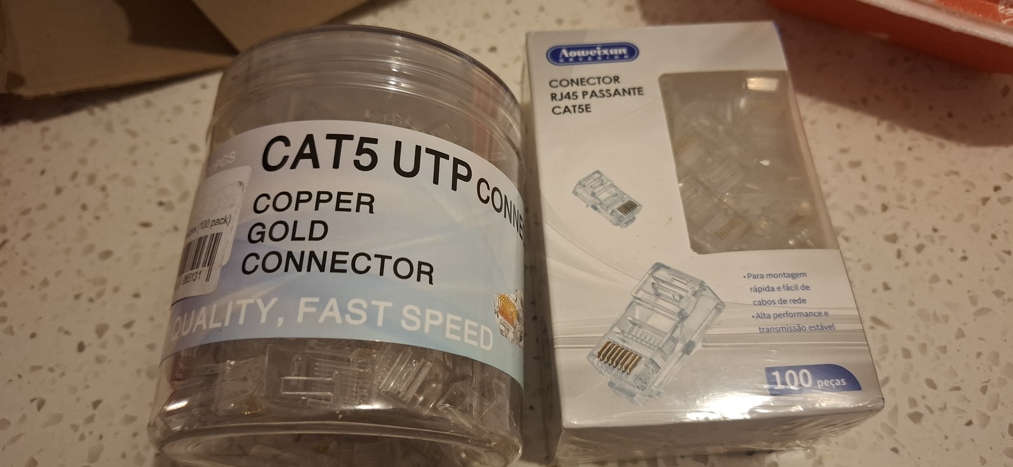 a cylindrical pack of 100 CAT5 UTP connectors, and a second rectangular pack of what is described as 'CAT5E RJ45'