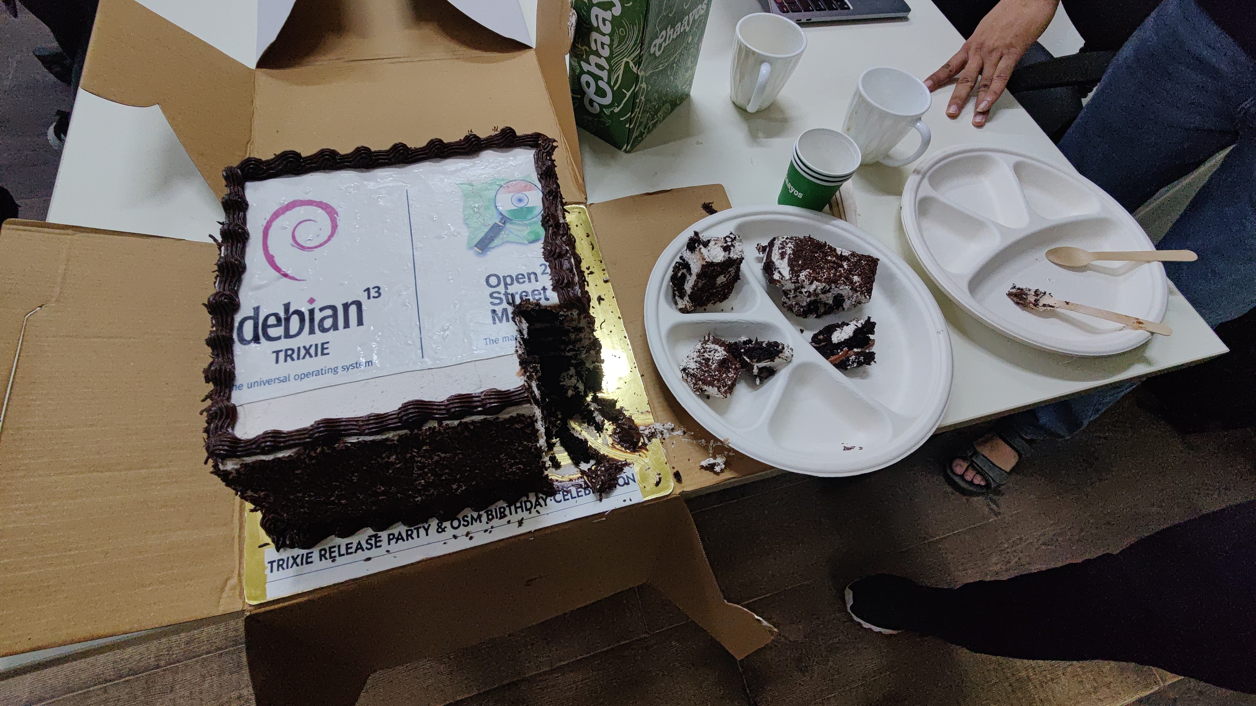 Cake picture with Debian trixie and OSM 21st logo along with tea